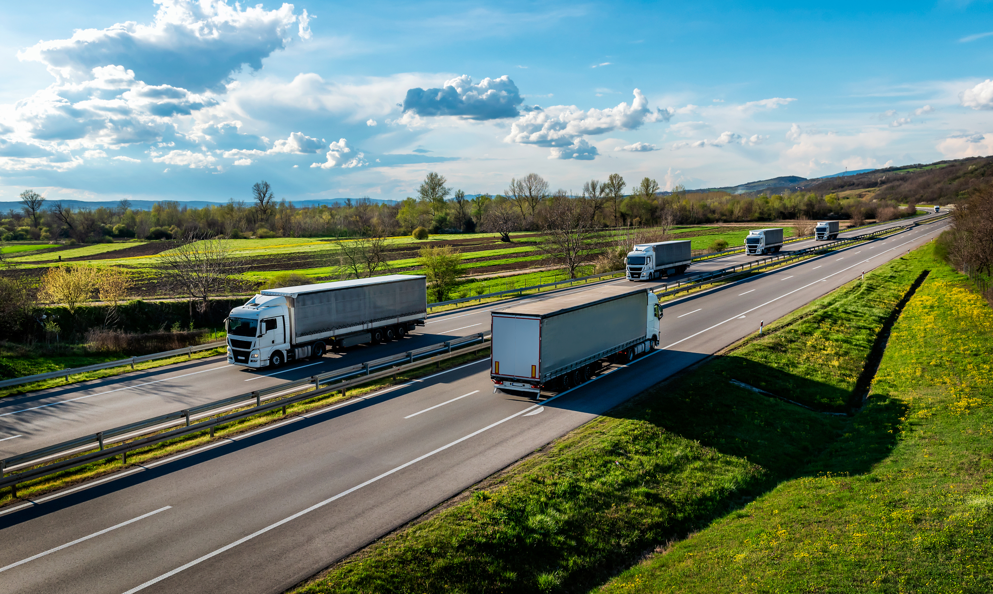 White Transportation Trucks in lines passing