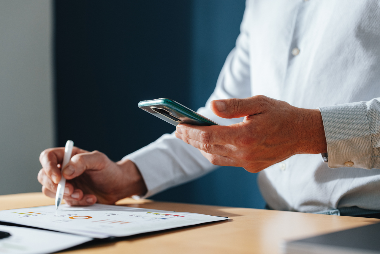 Unrecognizable Businessman Using A Mobile Phone At Home